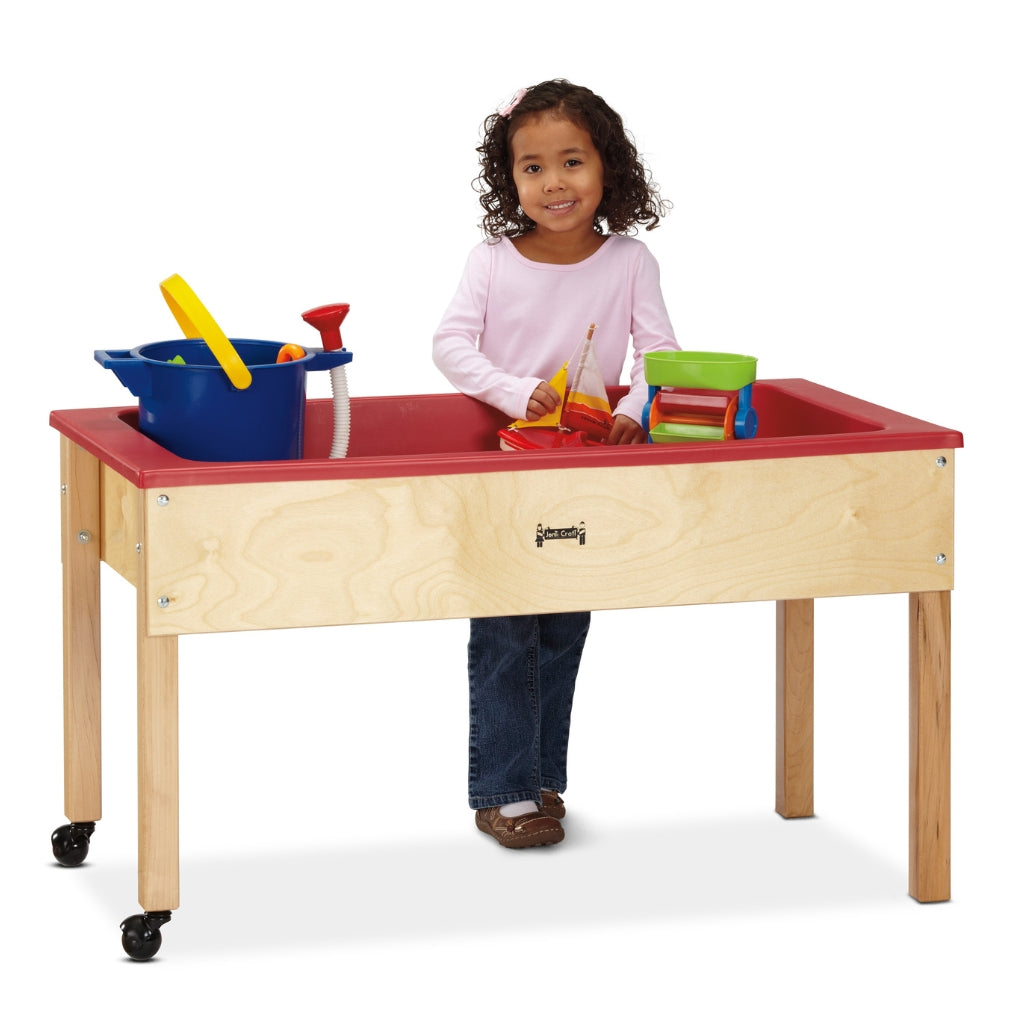 Child playing with toys on a colorful activity table against a white background