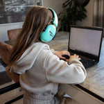 Girl on a laptop with noise canceling headphones on