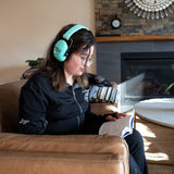 Wearing sensory headphones, reading a book
