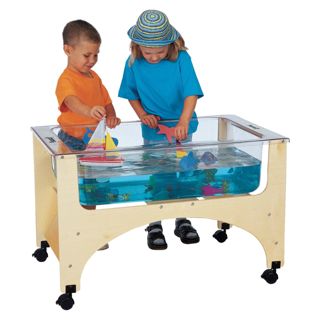 Two children playing with toys in a transparent water table filled with water and toy fish.