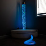 Blue bubble tube light in a dark room with a window in the background